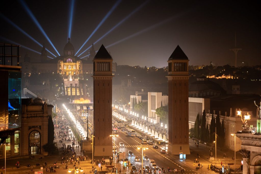 A vibrant night view of Barcelona with the National Palace illuminated against the sky.