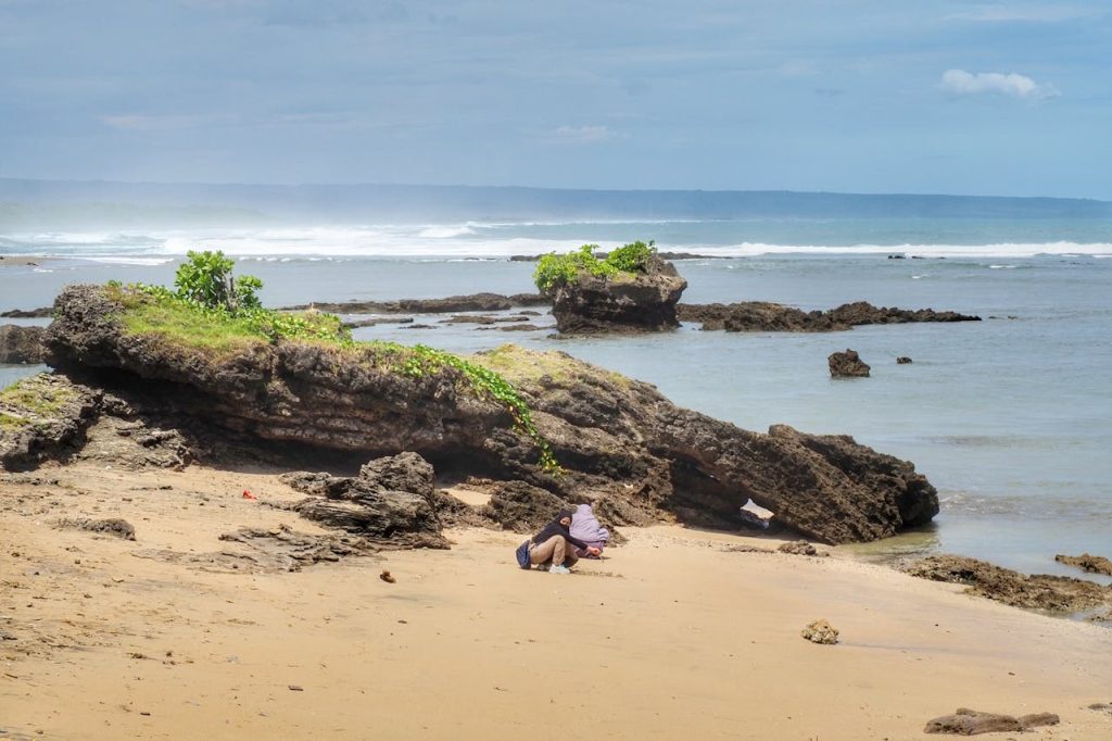 Peaceful coastal view with rocks and ocean waves in West Java, Indonesia.